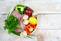 Rabbit raw meat, vegetables, mushrooms spices on a round tray, rustic background. Flat lay top view, place for text Royalty Free Stock Photo