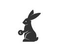 Rabbit silhouette holding coin vector illustration. Black and white bunny logo. Isolated on white background