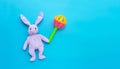 Rabbit toy with colorful baby rattle on blue Royalty Free Stock Photo