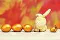 Rabbit toy and easter golden eggs on colorful background Royalty Free Stock Photo