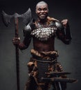 Rabid african warrior in steel armor and fur wielding an axe in studio