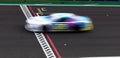 Race car blurred motion crossing finish checkered line Royalty Free Stock Photo