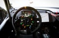 Race car driver point of view inside cockpit, steering wheel with knobs and Honda logo