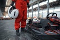 Racer with helmet poses near go kart car, karting Royalty Free Stock Photo