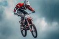 Racer jumping on a cross motorcycle against the cloudy thunder sky. Teenager in bright uniform and protective helmet Royalty Free Stock Photo