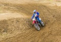 The racer on a motorcycle participates in race motocrosses, goes on sand. Close-up.