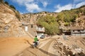 Racer on motorcycle rides through the mountain village on dirt road in Kurdistan Royalty Free Stock Photo