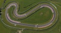 Racetrack with a twisting, looped layout surrounded by green grass fields. The asphal Royalty Free Stock Photo