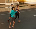 Racing against sunrise. a group of friends jogging down a road in the early morning.