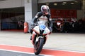 Racing bike rider on a sports motorcycle leaves the pits