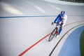 Racing cyclist on velodrome outdoor.