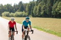 Racing cyclists couple riding in the countryside, tracking shot