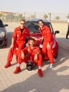 Racing team posing in front of Mini