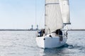 Racing yacht with white sails in a calm sea