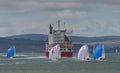 Racing yachts and a containers ship on the Solent during Cowes Week regatta.