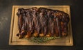 Rack of beef ribs cooked and placed on a wood cuttingboard with a sprig of rosemary Royalty Free Stock Photo