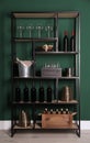 Rack with bottles of wine and glasses near green wall Royalty Free Stock Photo