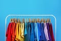 Rack with bright clothes on background. Rainbow colors Royalty Free Stock Photo