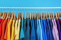 Rack with bright clothes on background. Rainbow colors Royalty Free Stock Photo