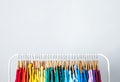 Rack with bright clothes on blue background. Rainbow colors Royalty Free Stock Photo