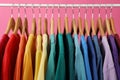 Rack with bright clothes on background. Rainbow colors Royalty Free Stock Photo