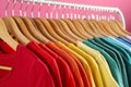 Rack with bright clothes on background. Rainbow colors Royalty Free Stock Photo