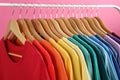 Rack with bright clothes on background. Rainbow colors Royalty Free Stock Photo