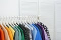 Rack with bright clothes in room Royalty Free Stock Photo