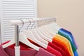 Rack with bright clothes in room. Royalty Free Stock Photo