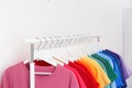 Rack with bright clothes in room. Royalty Free Stock Photo