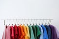 Rack with bright clothes on white background. Royalty Free Stock Photo