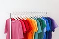 Rack with bright clothes on white background Royalty Free Stock Photo