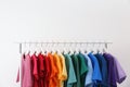 Rack with bright clothes on white background. Royalty Free Stock Photo