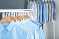 Rack with clean clothes on hangers after dry-cleaning