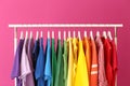 Rack with rainbow clothes on color background Royalty Free Stock Photo