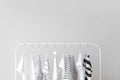 Stylish kid clothes hanging on rack against light background Royalty Free Stock Photo