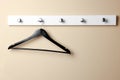 Rack with empty black clothes hanger on beige wall Royalty Free Stock Photo