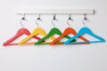 Rack with empty bright clothes hangers on white wall Royalty Free Stock Photo