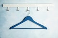 Rack with empty clothes hanger on color wall. Royalty Free Stock Photo