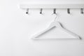 Rack with empty clothes hanger on white wall Royalty Free Stock Photo