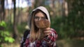 Rack focus from beautiful smiling woman to mushroom in female Caucasian hand. Confident young gatherer picking fungi in