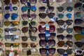 A rack full of various sunglasses for sale outside a seaside shop Royalty Free Stock Photo