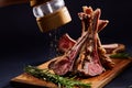 Rack of lamb with rosemary on wooden cutting board over dark background, side view, selective focus Royalty Free Stock Photo