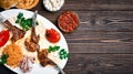 Rack of lamb or turkish pirzola kuzu with bulgur, grilled vegetables and spices on a white plate. Dark wood background, top view Royalty Free Stock Photo