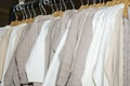 Rack in modern clothing store with knitted cotton sweaters in white and beige on hangers Royalty Free Stock Photo