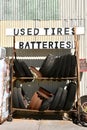 Rack of old tires and batteries available at a repair garage