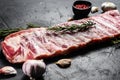 Rack of raw pork spare ribs seasoned with spices. Black background. Top view Royalty Free Stock Photo