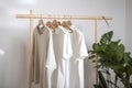 a rack of shirts hanging on a clothes rack next to a potted plant and a potted plant in a corner of a room