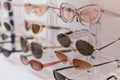 Rack with stylish trendy plastic glasses. Retail sale of stylish glasses