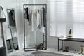 Rack with stylish women`s clothes and large mirror in dressing room. Interior design Royalty Free Stock Photo